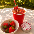 Load image into Gallery viewer, Summer Pimm's & Strawberries paper straw toppers in a drink cup with strawberries and a decorative tin.