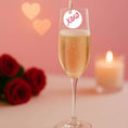 Load image into Gallery viewer, Valentine's drink toppers on a champagne glass with a tag saying 'XOXO' and roses in the background.