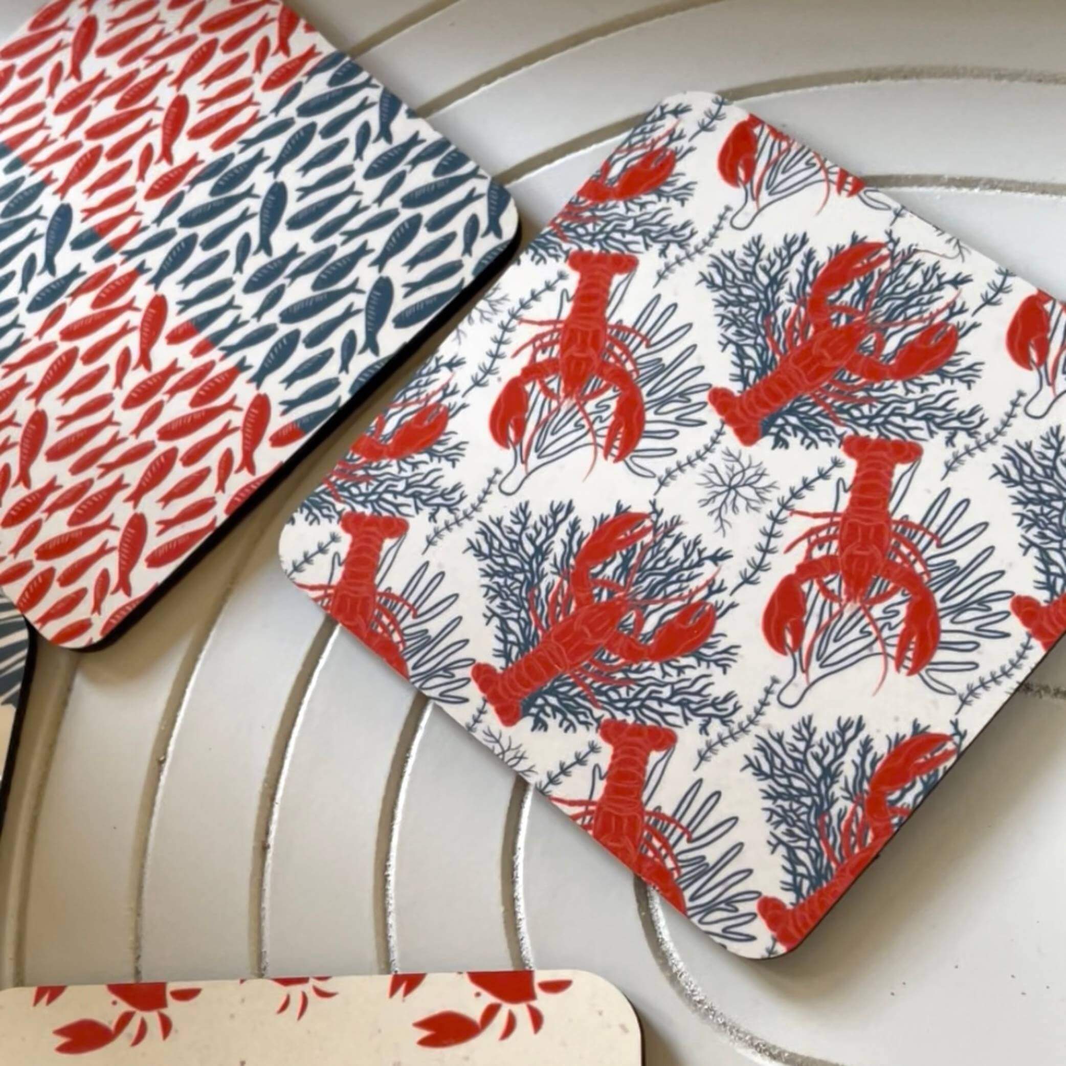 Salty Days - coastal drink coasters set of 4 with vibrant coral and blue designs of shells and lobsters.