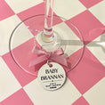 Load image into Gallery viewer, Wine glass with a 'Baby Brannan' tag on a pink and white checkered background
