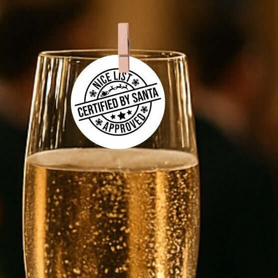 Santa's Nice List Christmas edible drink toppers on a champagne glass for festive decorations.