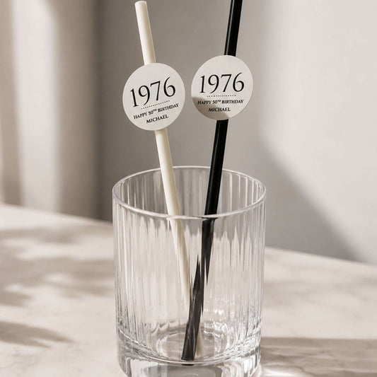 Personalised birthday year straw toppers in a glass, featuring '1976' toppers for a special birthday celebration.