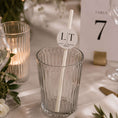 Load image into Gallery viewer, Occasion paper straws personalised initials toppers in a clear glass at a wedding table setting.
