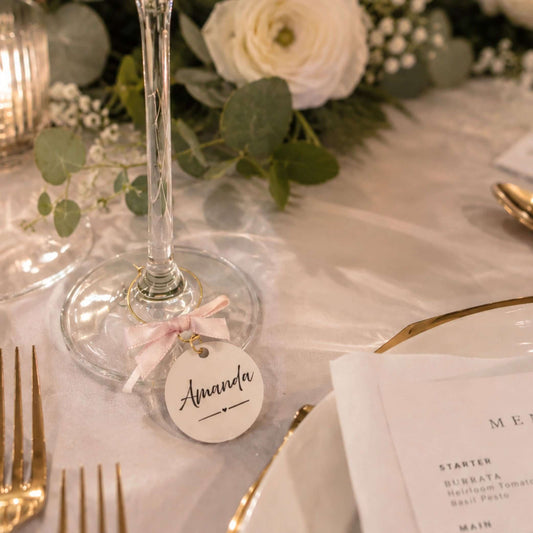 Personalised name wine glass charms with a tag labeled Amanda at a beautifully set table.