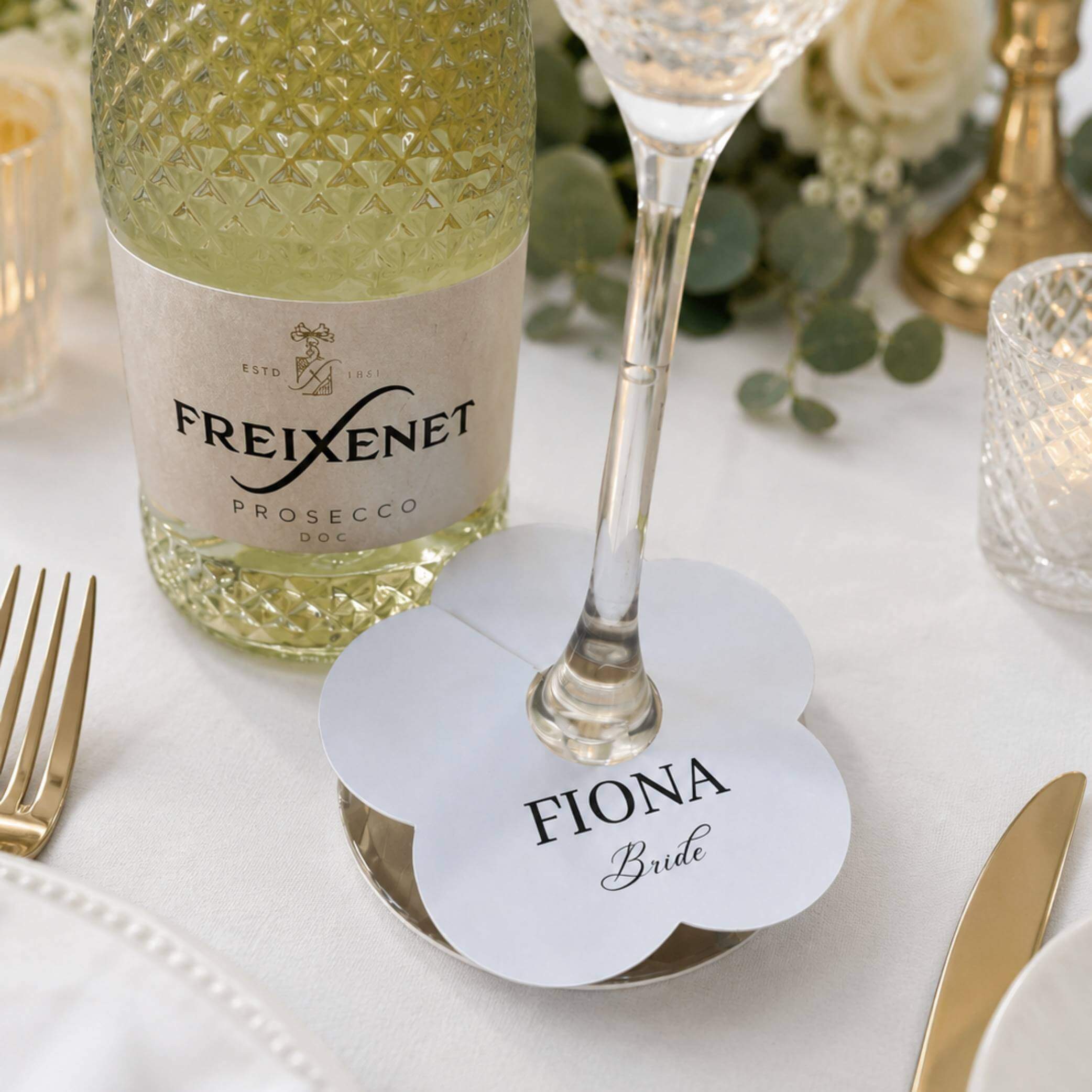 Wedding Attendees white personalised name drink marker with the name Fiona and the title Bride next to a glass of Prosecco.