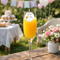 Load image into Gallery viewer, Mum To Bee edible drink topper on a glass of orange juice at a baby shower celebration.

