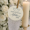 Load image into Gallery viewer, Happy Heavenly Mothers Day Edible Wafer Drink Toppers attached to a glass with flowers and candle in the background.
