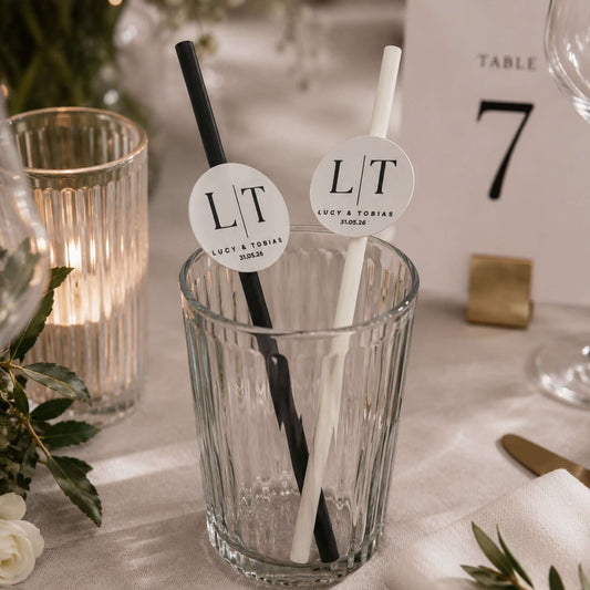 Occasion paper straws personalised initials toppers in a glass with black and white straws for weddings and events.