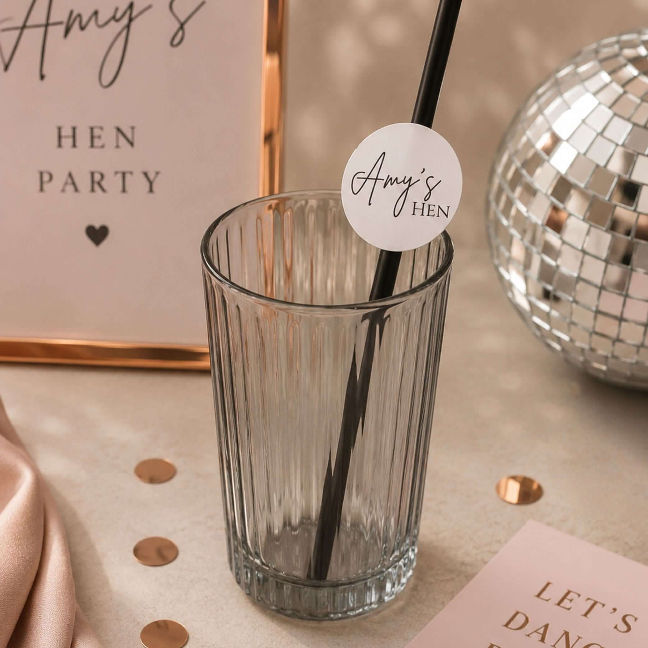 Hen party paper straws personalised toppers in a glass, featuring a custom topper that says 'Amy's Hen'.