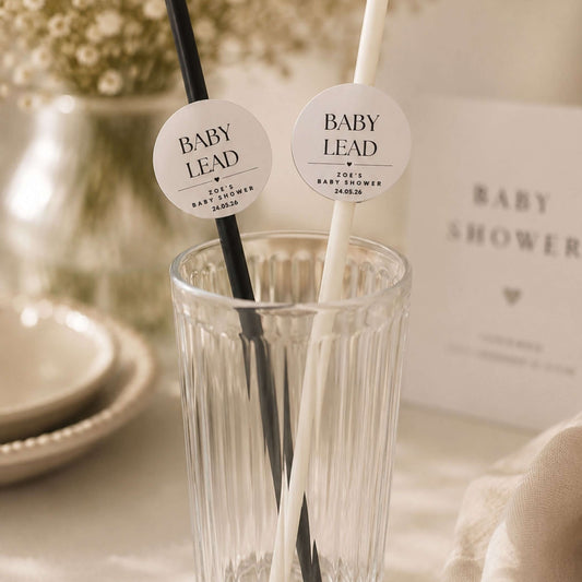 Personalised baby name paper straw toppers in black and white colors in a glass for baby shower celebrations.