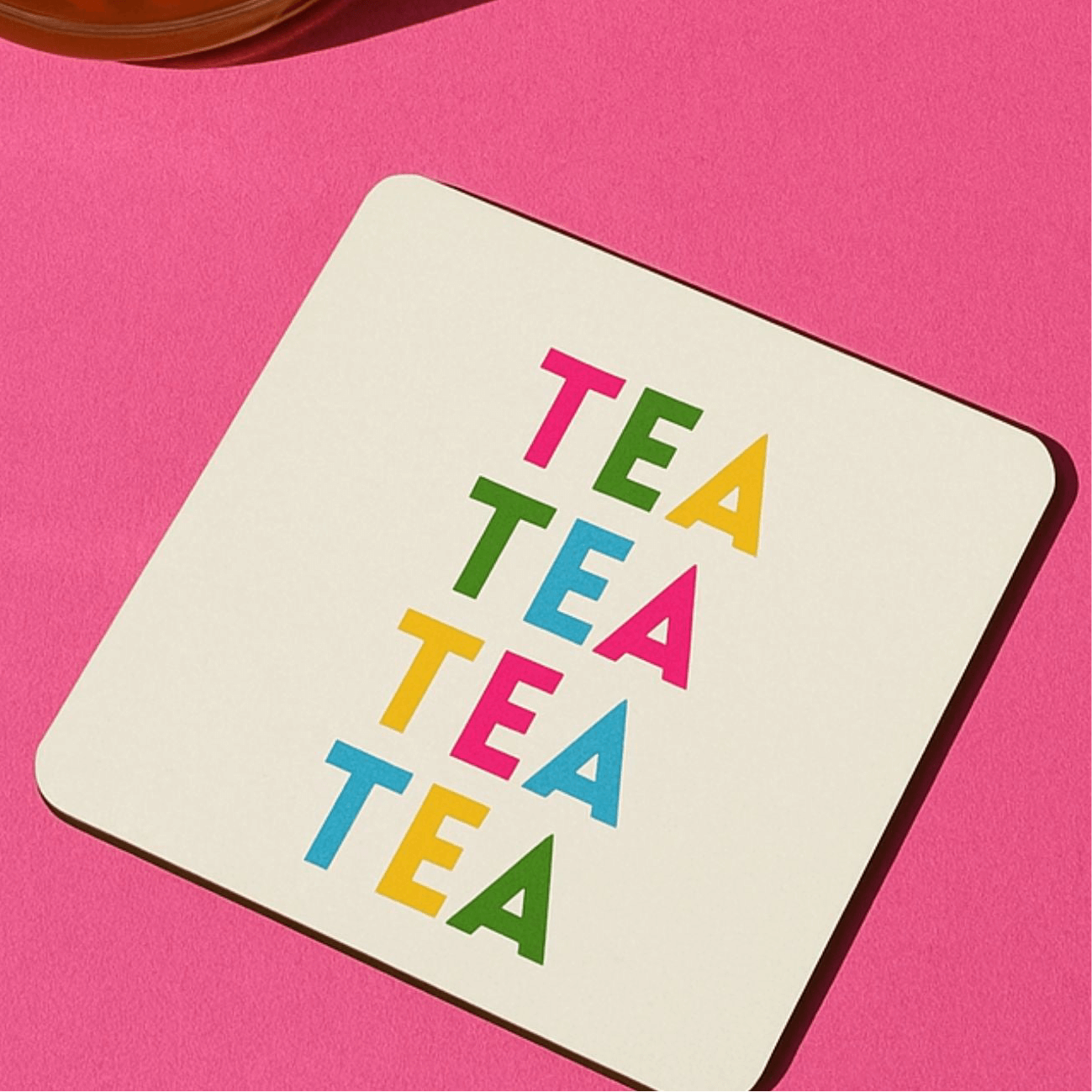 Tea themed drink coaster displayed on a vibrant pink background with colorful 'TEA' text design.