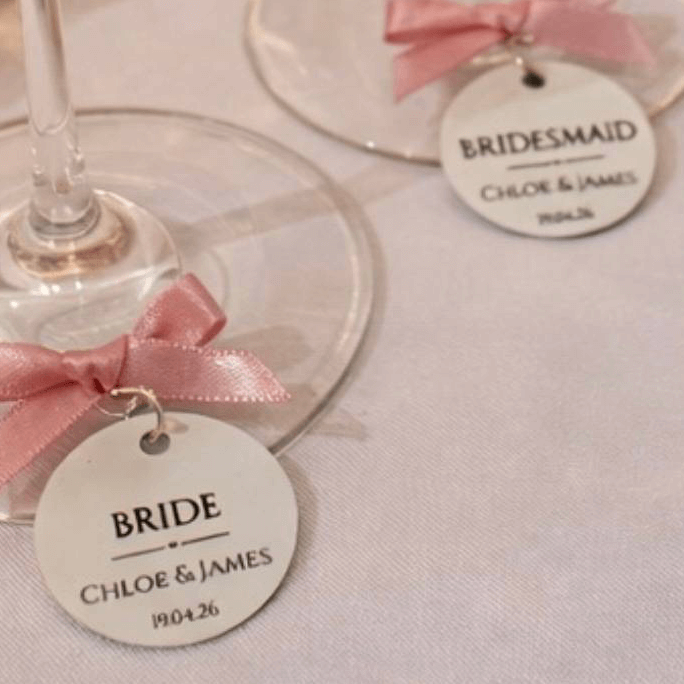 Wedding Wine Charms for Bridal Party with tags for Bride and Bridesmaid with pink bows.