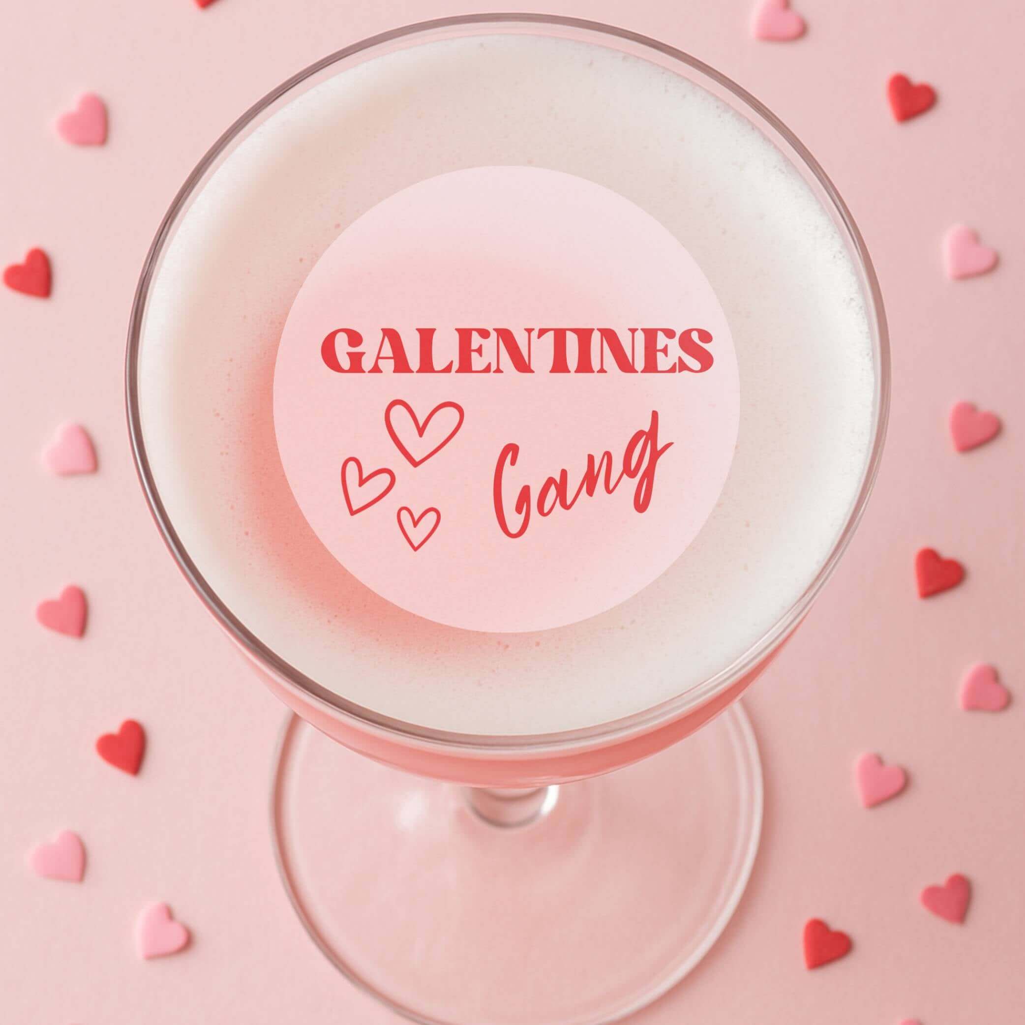 Edible drink toppers for cocktails featuring 'Galentines Gang' on a pink cocktail surrounded by heart-shaped sprinkles.
