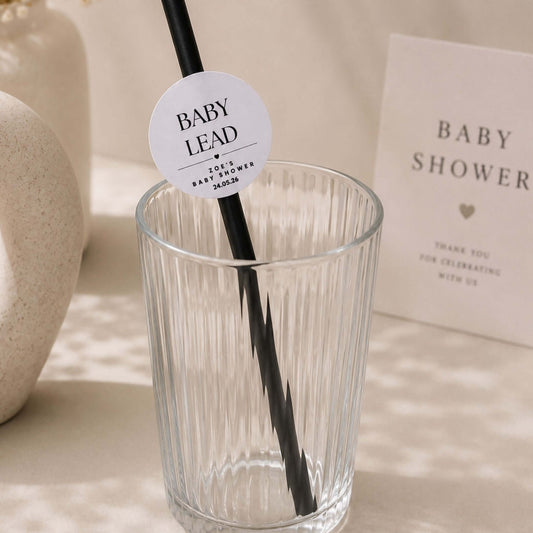 Personalised baby name paper straw toppers in a clear glass for baby shower party decoration.