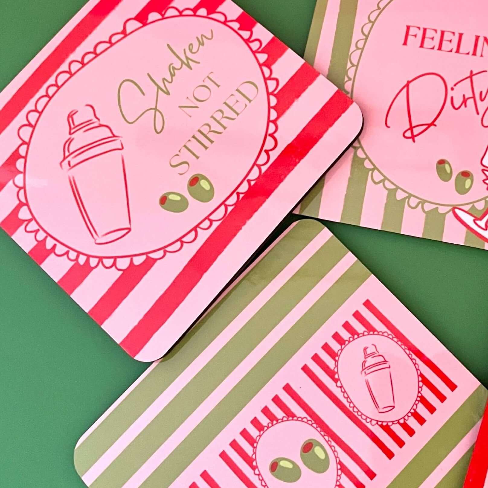 Feeling Dirty martini drink coasters featuring designs with cocktail shaker and olives on vibrant backgrounds.